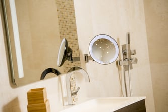 Miroir cosmos lumineux par JVD dans une salle de bain de chambre d'hôtel en installation bras plat articulé sur cinq axes avec une vision grossissante x5